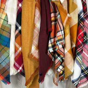 Image of a variety of different flannel bandanas in an array of colors and patterns.