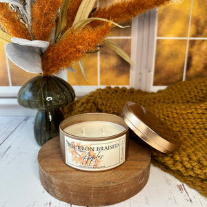 Candle on a wooden holder with a label, surrounded by decorative elements on a wood surface.