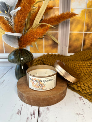 Candle on a wooden holder with a label, surrounded by decorative elements on a wood surface.