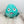 Plush dog toy that resembles a pufferfish with a blue body and a cartoon face. 