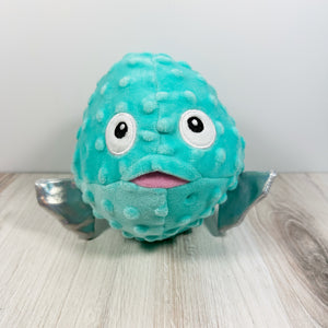 Plush dog toy that resembles a pufferfish with a blue body and a cartoon face. 
