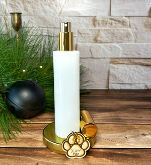 White and gold bottle room spray on a wooden surface with decorative elements