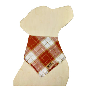 Plaid bandana on a dog-shaped wooden cutout. The plaid features colors of rust, orange, tan, and white. There is a brand label visible on the bandana for 'Charlie & the Hound'.