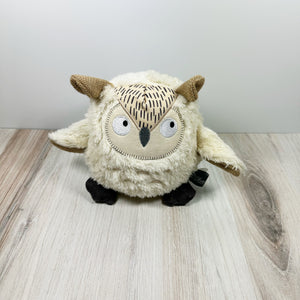 Owl-shaped dog toy made from natural and earth friendly materials. The toy is sitting on a light wooden surface with a white background. 