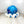 Plush blue tie-dyed octopus dog toy with white accents and a smiling face. Toy is sitting on a light wooden surface with a white background.