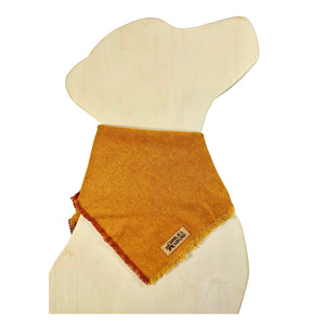 Orange flannel bandana on a dog-shaped wooden cutout featuring a brand label 'Charlie & the Hound'.