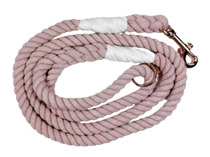 Rose colored rope dog leash with rose gold hardware and charm coiled up a white background. 