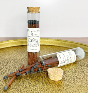 Safety matches in a glass vial with cork lid on metal tray and wooden surface