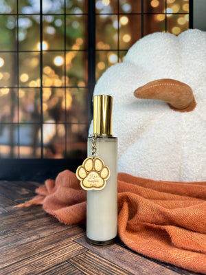 Room spray bottle with gold cap on a wooden surface with a blurred background