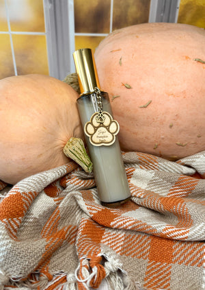 Room spray, featuring a seasonal autumn scent with a wooden tag and pumpkins and plaid fabric in the background.