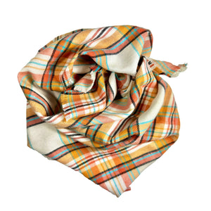 Plaid dog bandana. The plaid is a combination of colors including cream/beige, blue, orange, coral, and black.
