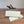 Two snap bar wax melts on a wooden surface leaning against a gray rock with wooden sticks.